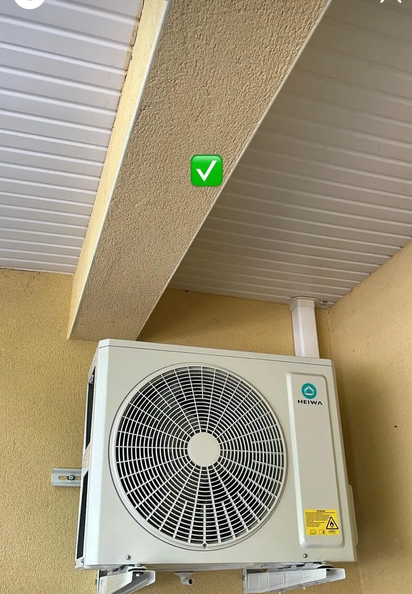 Unités extérieures de climatisation fixées en hauteur sous la toiture